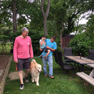 father and son walking a dog with tom