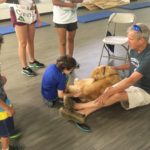 Kids at the Kinney Center pet a dog