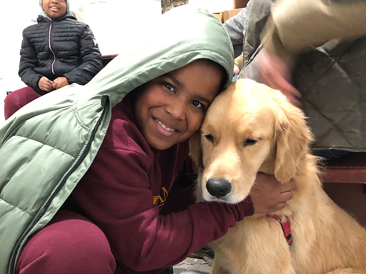 child hugging dog