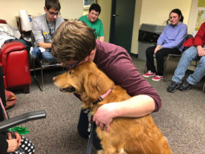 Student hugging a support dog