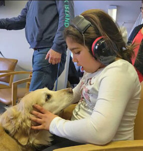 Student Giving Nellie's schoolhouse dog pets on the head